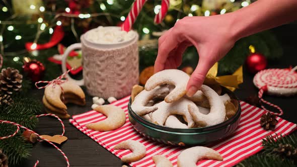 Woman Puts Traditional German or Austrian Vanillekipferl Vanilla Kipferl Cookies in a Gift Box