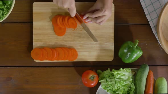 woman making healthy food and chopping carrot on cutting board in the kitchen.