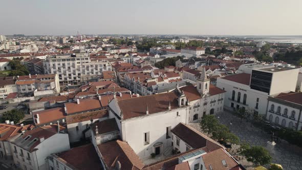 Aerial pan shot capturing church of aveiro's mercy, district council populated cityscape from above.