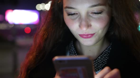 Portrait of young beautiful caucasian using smart phone outdoor in the city night