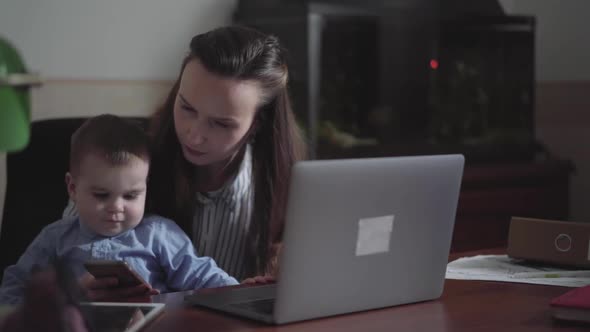 Baby Son Sitting on Mothers Lap at the Table