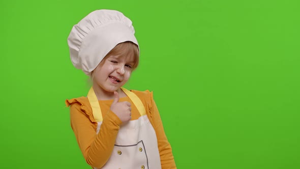 Child Girl Dressed Cook Chef Baker in Apron and Hat Showing Thumbs Up Fooling Around on Chroma Key