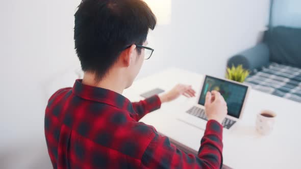 Young Asian Man Relaxing on the Chair Satisfied with His Work