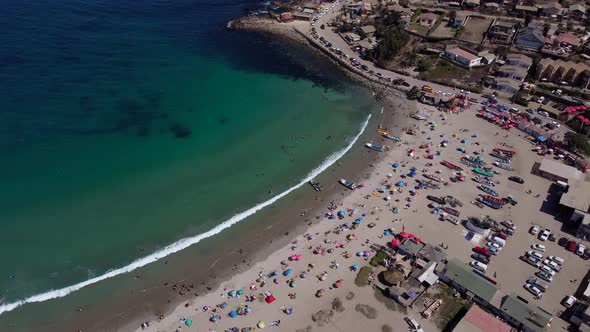 Aerial view invites us to enjoy the summer with parasol, sand and turquoise sea.