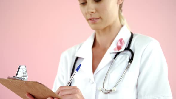 Portrait of doctor writing on clipboard