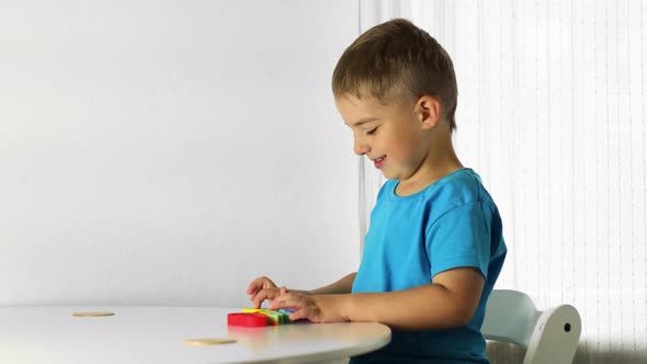 Little boy plays with rainbow Pop it fidget toy. 