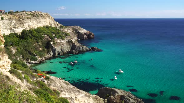 Boats and Yachts in the Rocky Bay with Crystal Clear Azure Sea on a Sunny Day