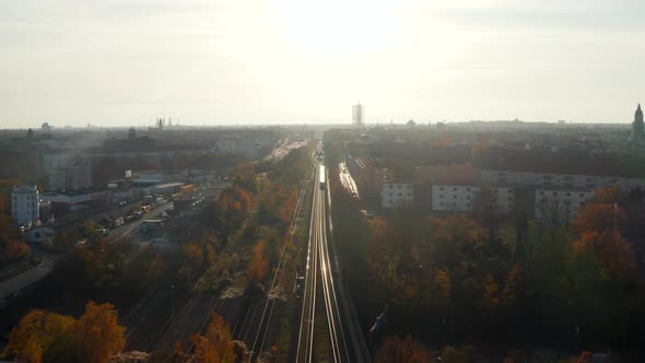 Elevated View Above Train Tracks Going Through City with a Train in the Distance, Aerial Wide View