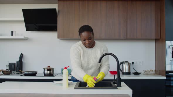 Lovely African Woman Washing Dishes in Domestic Kitchen