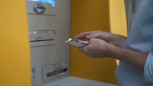 Close Up of Man's Hand Insert ATM Card Into Automated Teller Machine (Automatic Banking Machine) To