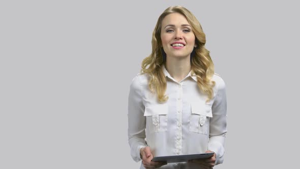 Young Woman Swiping Tablet Pc and Giving Speech To Audience