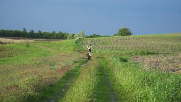 Woman Cyclist Moving On Bike On Countryside