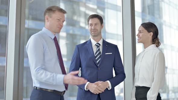 Middle Aged Businessman Having Discussion with His Assistants in Office