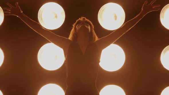 Beautiful woman dancing in front of a wall of lights