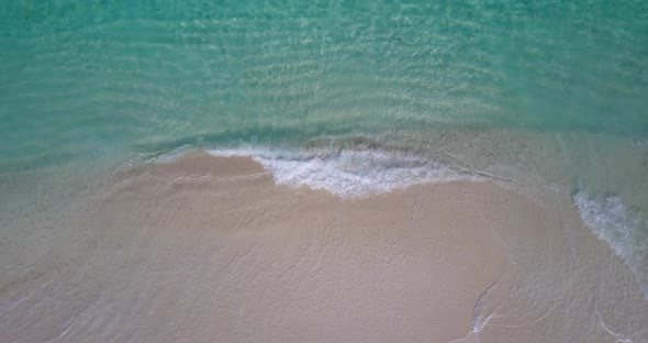 Tropical flying tourism shot of a paradise sunny white sand beach and aqua turquoise water backgroun