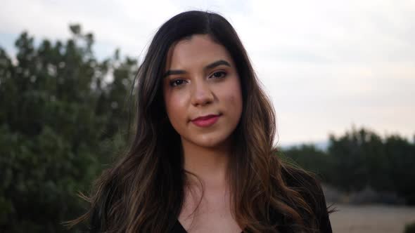 Attractive young independent adult hispanic woman looking with happy, smiling eyes at the camera wit