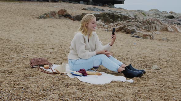 Young Woman Has Video Call On Beach