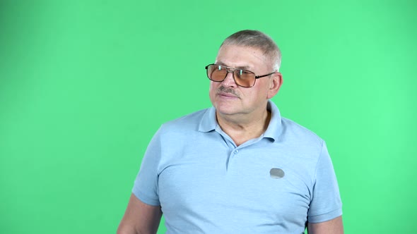 Portrait of Aged Man Is Shocked By What He Saw, Isolated Over Green Background.