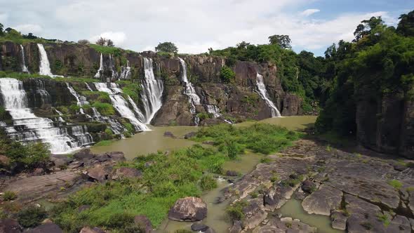 Drone Flight Over a Natural Park with Picturesque Waterfall Cascade and Greneery