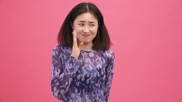 Pretty Asian woman suffering from bad smell