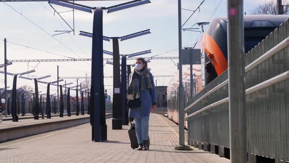 Woman in Face Mask Walking Along Railway Platform