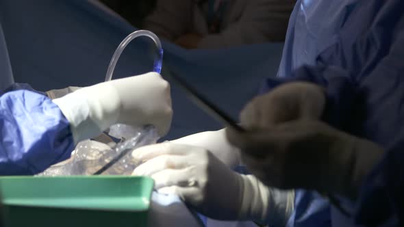 Surgeons working during surgery, close up on hands and instruments.