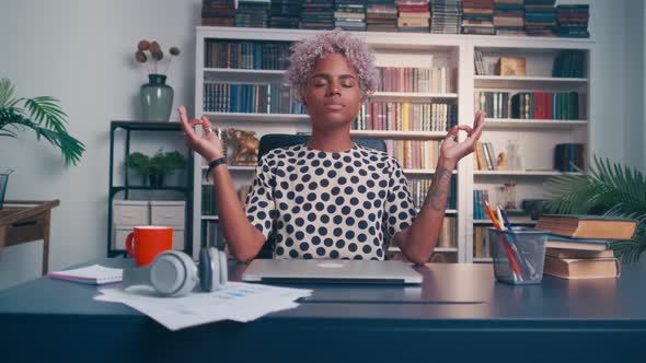 Young African American Woman Meditates at Workplace Doing Breathing Practices