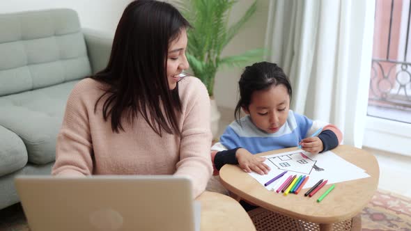 Latin mother and son kid having fun together while mom is working at home - Family love concept