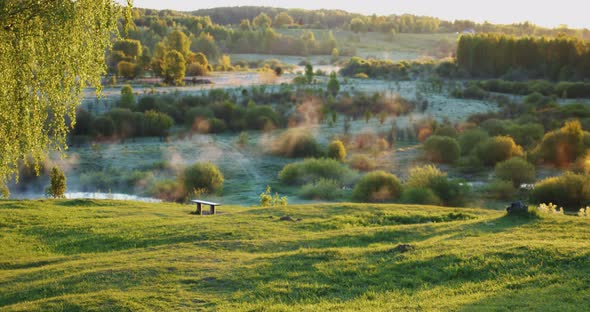 An Ideal Place for Privacy a Bench and a Green Hill Overlooking the Valley with Fog and Steam