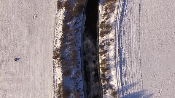 Aerial view of Vaana Jogi river surrounded by snow in winter in Estonia.