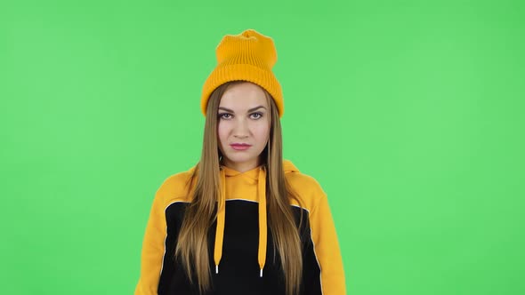 Portrait of Modern Girl in Yellow Hat Is Threatening, Showing Gestures While Looking at the Camera