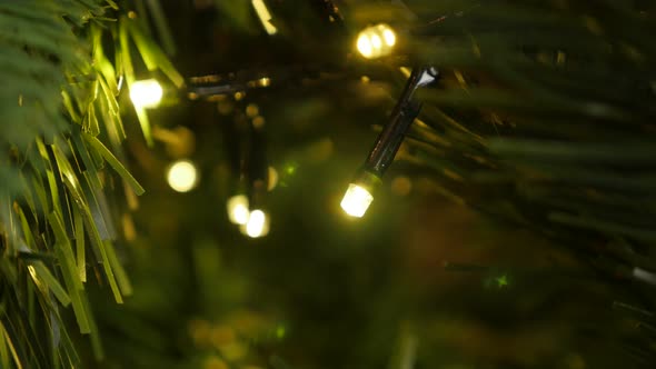 Fairy lights sparkling on the tree close-up 4K 2160p UHD footage - Christmas warm color decorative l