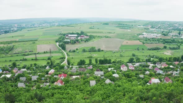 Flying Over a Dense Forest Then a Residential Rural Area