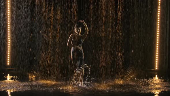 Silhouette of an Attractive Woman in a Wet Tight Dress Enjoying a Flamenco Dance in the Rain. Black