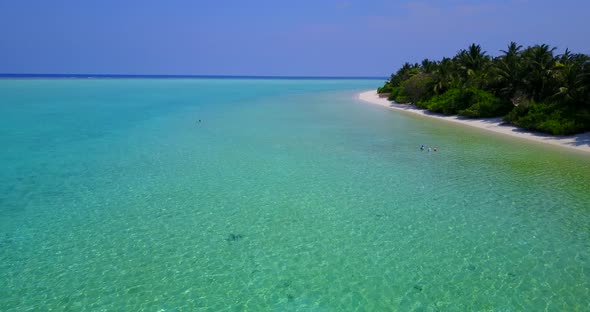 Daytime fly over abstract view of a white paradise beach and aqua blue ocean background 