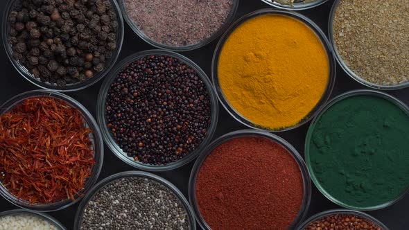 Assortment colorful spices, seeds and herbs for cooking food rotate, top view