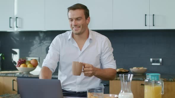 Smiling Man Drinking Coffee During Skype Call. Closeup Man Having Online Chat