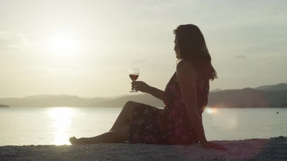 Romantic Landscape of the Sea a Girl Drinks Wine on the Beach at Sunset