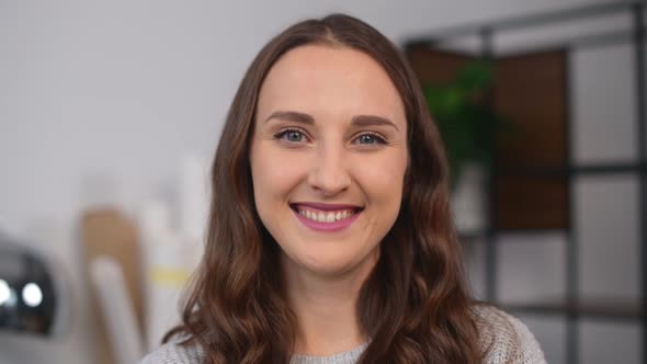 Charming Young Woman Looks at the Camera and Smiling