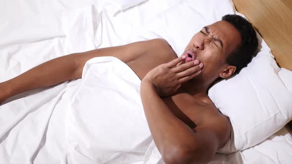 African Man Lying in Bed Suffering Teeth Pain Toothache