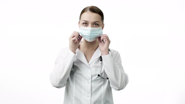 Young Beautiful Lab Technician in Medical Uniform Put on Protective Mask