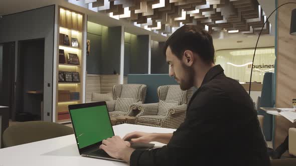 Young Focused Handsome Male Businessman Working on a Laptop