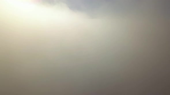 Reveal shot of aerial view from above of white puffy clouds. alt