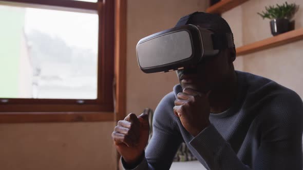 African American man wearing VR headset at home