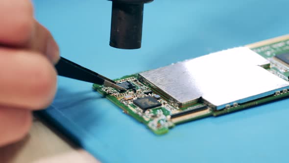 Close Up of a Microcircuit Getting Repaired