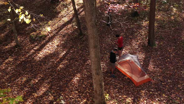 Two men set up a tent in the forest in the forest in autumn. Located in the Trout Run Valley of West