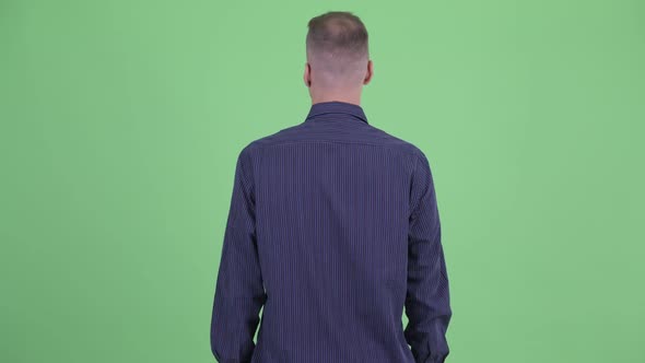 Rear View of Businessman Thinking and Looking Around