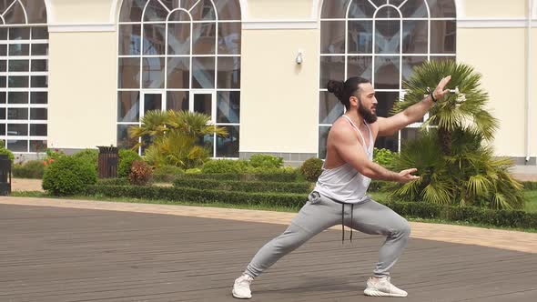 Man with Beard Doing Squats Training Outdoors Showing Power and Strength.