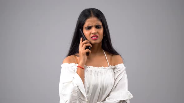 Angry Indian girl talking to someone using smartphone