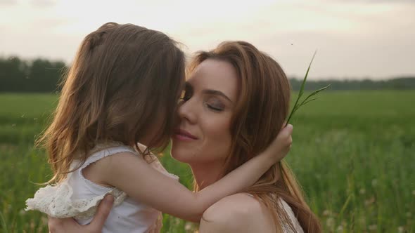 Mom and Daughter in the Green Field Enjoy Nature